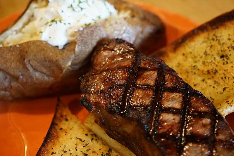 Steak with garlic bread and baked potato