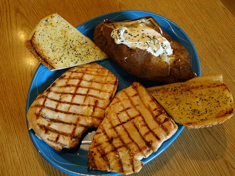 Chicken with side of garlic bread and baked potato